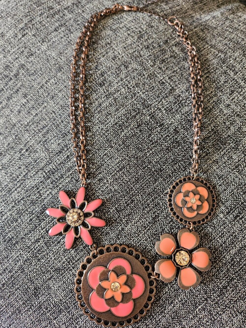 Copper chain necklace with pink flower pendant and rhinestone center.